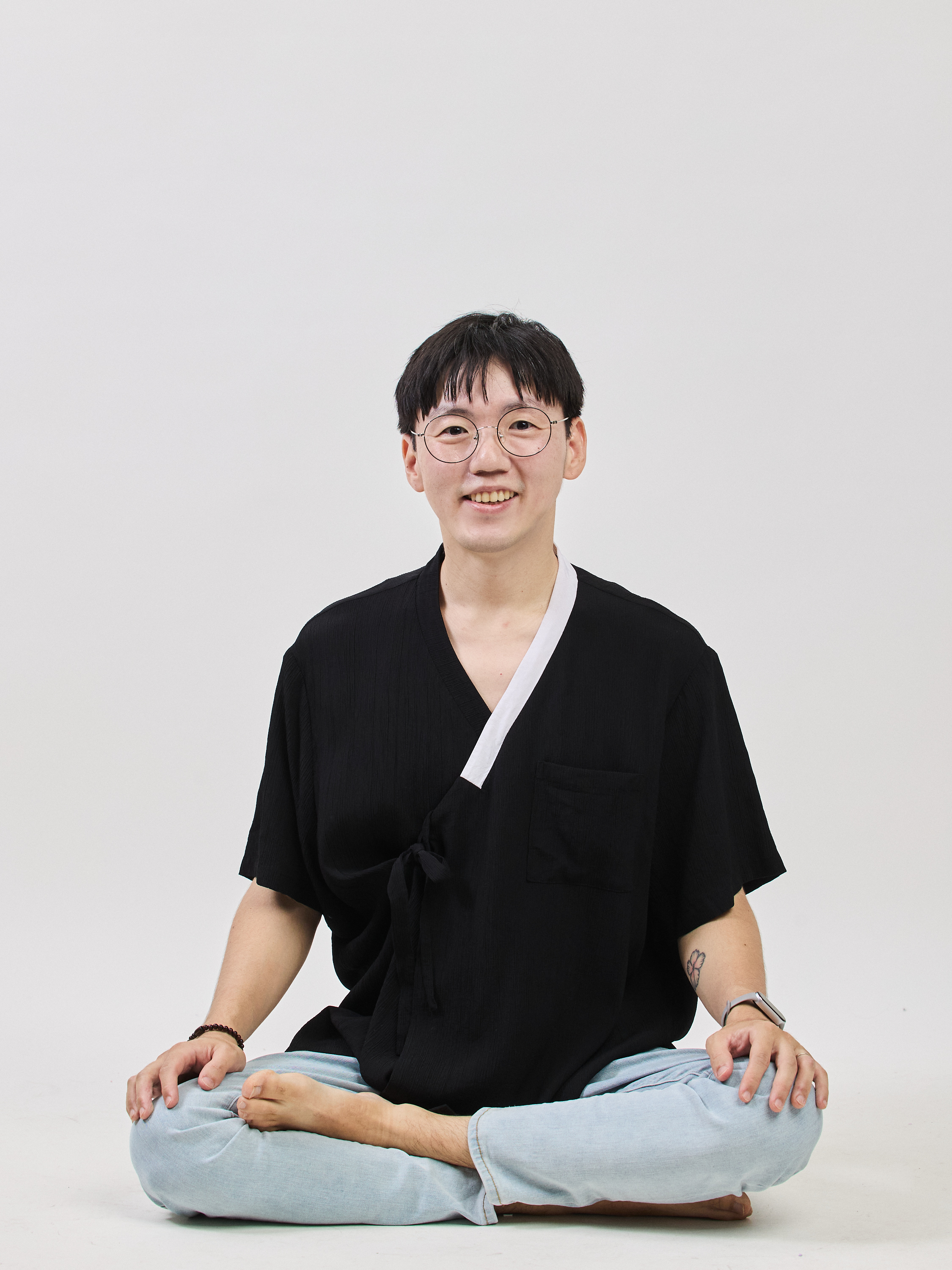 Billy Seol seated in a relaxed, serene pose — embodying peace over hustle